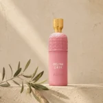 Assaf Delina Erik Eau de Parfum for Women bottle on a warm limestone background with a subtle olive branch and soft natural daylight.