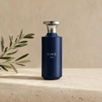 Assaf King Enable Eau de Parfum for Men 150ml bottle on a warm limestone surface with a subtle olive branch, photographed in soft natural daylight.