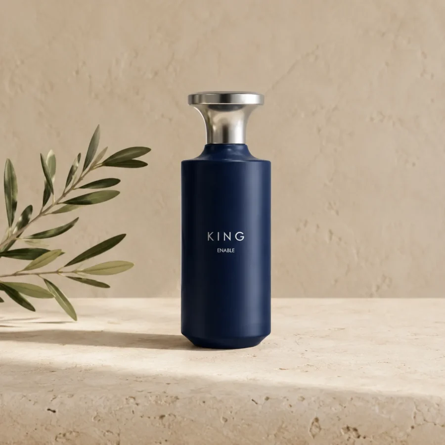 Assaf King Enable Eau de Parfum for Men 150ml bottle on a warm limestone surface with a subtle olive branch, photographed in soft natural daylight.