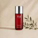 Assaf Risk Comete Eau de Parfum unisex fragrance bottle with silver cap on a warm neutral limestone background with a subtle olive branch.