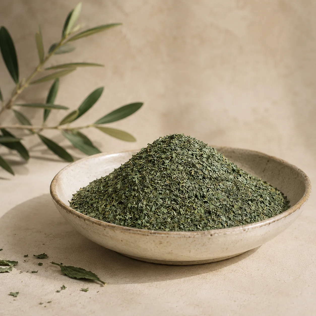 1-fine-molokhia-350g-hero Fine Molokhia 350g displayed in an aged white ceramic bowl with authentic fine-cut molokhia, subtle olive branch detail, warm neutral DARLEVANT background, and soft natural daylight.