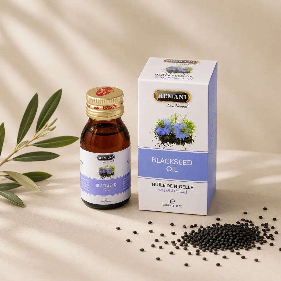 Hemani Black Seed Oil 30ml bottle with original retail box, whole Nigella sativa seeds, and olive branch on a warm neutral background.