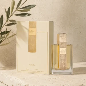 Lattafa Angham Eau de Parfum 100ml bottle with original box on a warm neutral limestone background with a subtle olive branch in soft natural daylight.