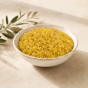 Premium Coarse Bulgur Wheat in an aged white ceramic bowl on a warm neutral DARLEVANT background with soft natural daylight and olive branch accents.