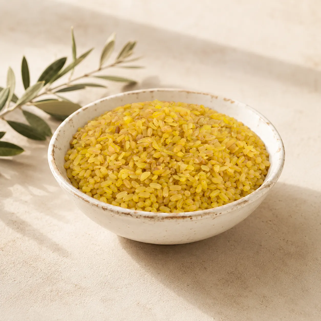 1-premium-coarse-bulgur-wheat-250g-hero Premium Coarse Bulgur Wheat in an aged white ceramic bowl on a warm neutral DARLEVANT background with soft natural daylight and olive branch accents.