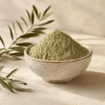 Premium Green Cardamom Powder 250g in a handcrafted white ceramic bowl with an olive branch on a warm neutral background.