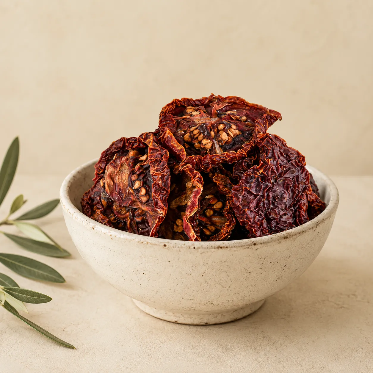 1-premium-jordanian-sun-dried-tomatoes-250g-hero Premium Jordanian sun-dried tomatoes in an aged white ceramic bowl with visible seeds, natural wrinkles, and rich red color on a warm neutral background.