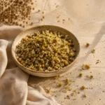 Dried chamomile flowers presented in a handcrafted ceramic bowl on natural limestone in a refined herbal pantry setting