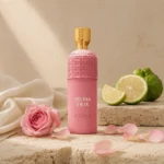 Assaf Delina Erik Eau de Parfum surrounded by fresh bergamot slices and delicate pink rose petals on warm limestone surfaces.