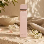 ASSAF Pink Lady Eau de Parfum bottle with jasmine blossoms and orange blossom petals on natural limestone