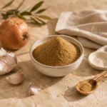 Ground coriander powder in a handcrafted ceramic bowl surrounded by fresh garlic, onion, natural linen, and an olive wood spoon in a warm Levantine kitchen-inspired editorial scene.