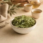 Premium Senna Leaves Herbal Infusion 250g in an artisanal ceramic bowl surrounded by softly blurred tea elements, linen textures, and warm natural light, highlighting traditional herbal infusion rituals.
