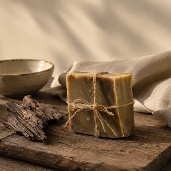 Traditional Oud and Amber Soap bar with natural oud wood and linen fabric in a refined handcrafted ritual setting