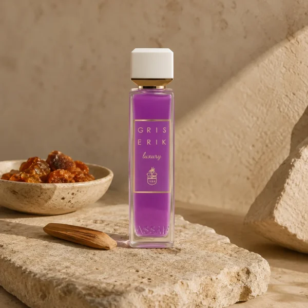 ASSAF Gris Erik Eau de Parfum bottle beside amber resin and sandalwood on natural stone in a warm earthy luxury fragrance setting