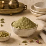 Premium Green Cardamom Powder 250g in a handcrafted ceramic bowl surrounded by pistachios and Levantine dessert-inspired elements in a refined culinary setting.