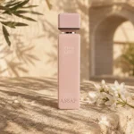 ASSAF Pink Lady Eau de Parfum bottle with orange blossom flowers beside a limestone arch in a warm Levantine inspired setting