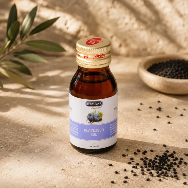 Hemani Black Seed Oil 30ml bottle on a limestone surface with scattered Nigella sativa seeds, olive branch, and warm Levantine-inspired natural light.
