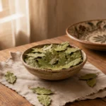 Dried bay leaves presented in a ceramic bowl on a Levant-inspired table with linen and natural wood textures
